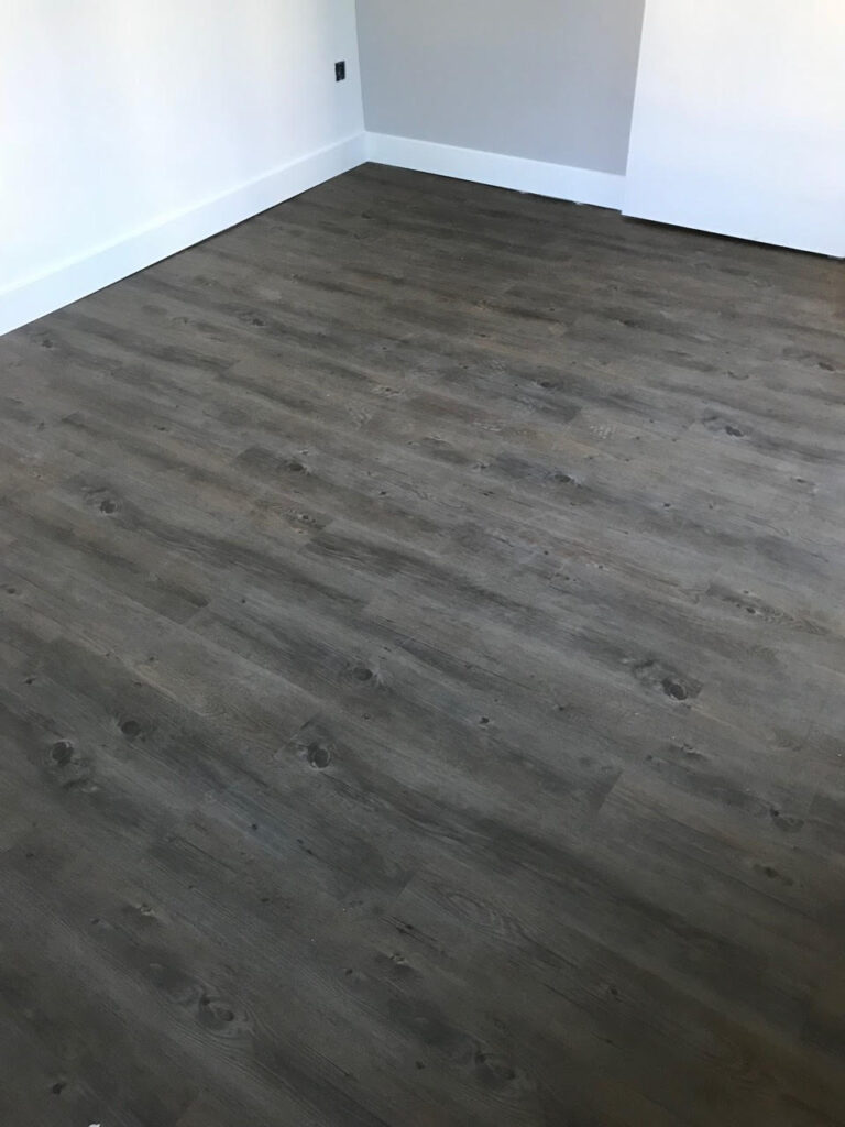 Fourniture et pose collée de revêtement de sol lames LVT avec plinthes blanches à Colmar près d’Ingersheim